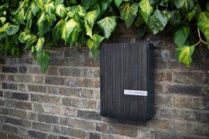 EV charger with acoya wood front panel on brick wall