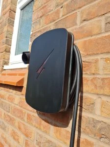 Black Hypervolt EV charger installed on brick wall