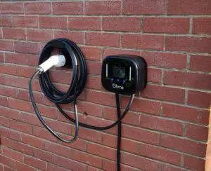 Tethered Ohme Pro charge point installed on brick wall